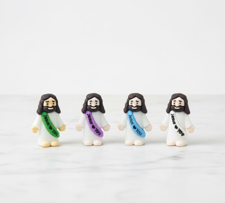 “Four miniature Jesus figurines with colorful sashes that read ‘Jesus ♥ You’ on a clean white background.”