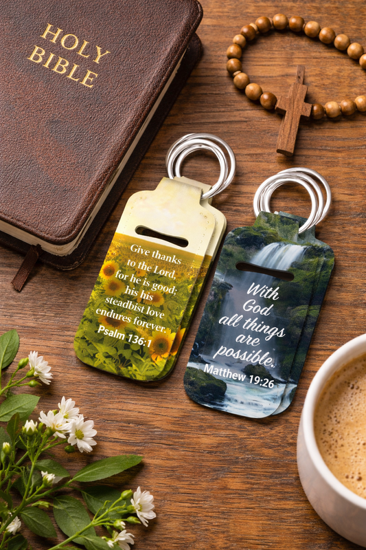 Scripture ChapStick Holder Keychains featuring Bible verses with mountain and nature backgrounds. Includes Psalm 136:1, 1 Corinthians 16:14, 2 Timothy 1:7, Matthew 19:26, Isaiah 41:10, James 4:8, Psalm 120:1, and Philippians 4:13. Bible & Coffee Cup Pictured